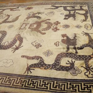 Close-up of an antique Chinese rug featuring stylized dragons and clouds on a light field, by Rugs On Net. by Rugs On Net