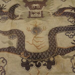 Close-up of a beige rug featuring a detailed, dark brown dragon motif with cloud elements, by Rugs On Net