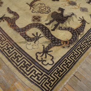 Close-up corner view of a beige rug featuring a dark brown dragon motif and geometric border, by Rugs On Net