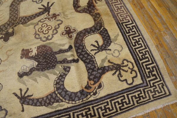 Close-up of a beige rug featuring a dark brown dragon motif and a greek key border, by rugs on net