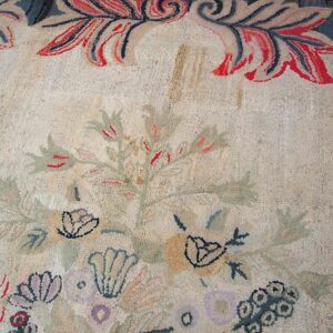 Close-up of a light-colored rug featuring faded floral motifs and a decorative border, by Rugs On Net