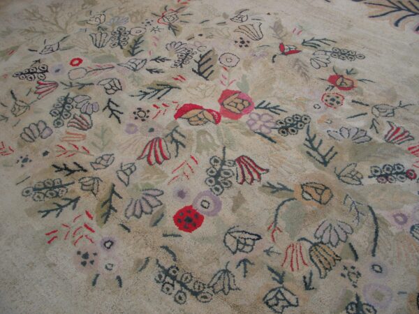 Close-up of a light-colored rug with abstract, scattered floral and leaf motifs in muted colors like red, purple, and dark green, by rugs on net