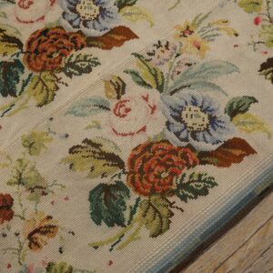 Close-up of a floral needlepoint rug with cream background and colorful blooms by Rugs On Net