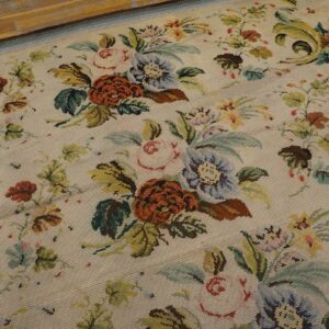 Close-up of a light-colored needlepoint rug featuring a dense, colorful floral pattern with roses and leaves by Rugs On Net. by Rugs On Net