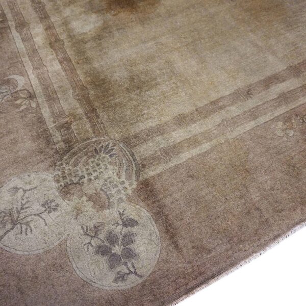 Close-up of the faded floral medallion detail on the brown oushak rug by rugs on net. By rugs on net