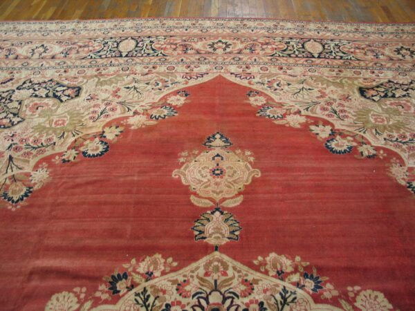 Close-up view of a red and cream oriental rug with intricate floral borders by rugs on net. By rugs on net
