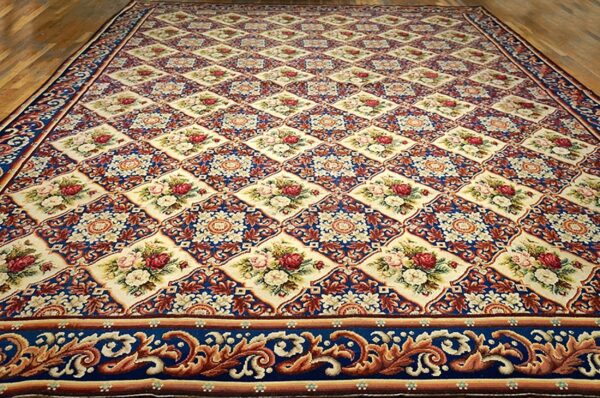 Close-up of a large, richly patterned rug featuring cream medallions with floral bouquets set against a dark blue background, by rugs on net
