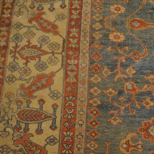 Close-up of the border and field of a traditional rug, showing blue, gold, and red patterns by Rugs On Net. by Rugs On Net