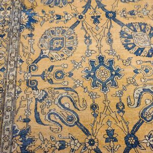 Close-up of the gold field and blue floral motifs of an antique Persian rug by Rugs On Net. by Rugs On Net