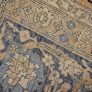 Close-up texture of a traditional rug with gold and dark blue geometric patterns by Rugs On Net
