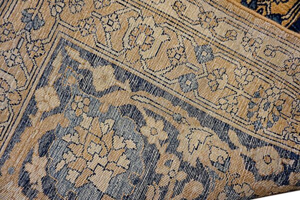 Close-up texture of a traditional rug with gold and dark blue geometric patterns by rugs on net