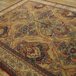 Close-up of a richly patterned, gold-toned area rug with floral motifs in red and blue by Rugs On Net. by Rugs On Net