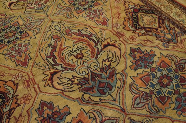 Close-up of an ornate, gold-toned rug with intricate red, blue, and orange floral patterns by rugs on net. By rugs on net