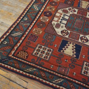 Close-up of a richly colored, geometric antique rug on wooden flooring by Rugs On Net. by Rugs On Net