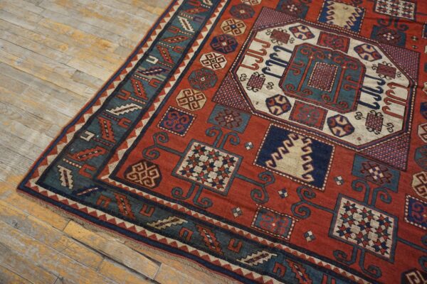 Close-up of a richly colored, geometric antique rug on wooden flooring by rugs on net. By rugs on net