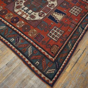 Close-up corner view of a richly colored antique rug with geometric patterns on distressed wooden flooring by Rugs On Net. by Rugs On Net