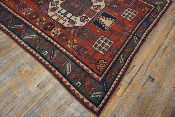Close-up corner view of a richly colored antique rug with geometric patterns on distressed wooden flooring by rugs on net. By rugs on net