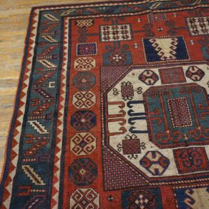 Close-up of a richly patterned red and blue Oriental rug on a light wood floor by Rugs On Net. by Rugs On Net