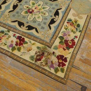 Close-up of a floral needlepoint rug corner on distressed wood floors by Rugs On Net. by Rugs On Net