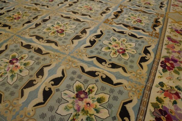 Close-up of a light blue needlepoint rug with floral medallions and black accents by rugs on net