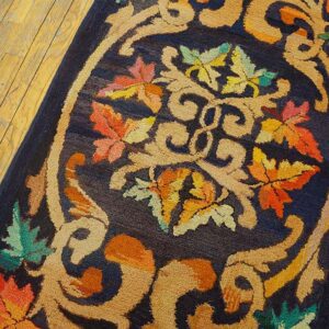Close-up of a dark blue rug with an ornate central medallion featuring colorful autumn leaves and tan scrollwork, by Rugs On Net. by Rugs On Net