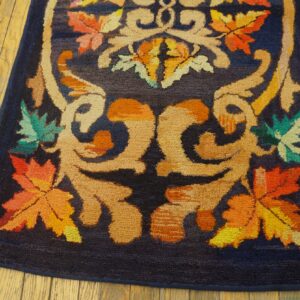 Close-up of a dark blue rug with vibrant orange, yellow, and green maple leaf motifs by Rugs On Net