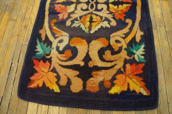 Close-up of a dark blue rug with vibrant orange, yellow, and green maple leaf motifs by rugs on net