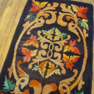 Close-up of the Autumn Foliage Navy Runner, showing vibrant autumn-colored leaves and beige scrolling patterns on a dark blue background, resting on wooden floorboards by Rugs On Net. by Rugs On Net