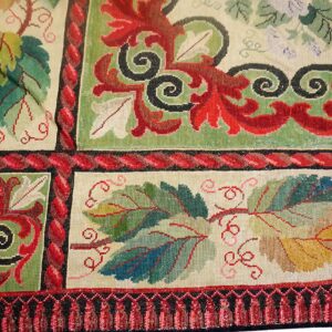 Detail of a tapestry rug featuring colorful grape leaves and scrolling vines, by Rugs On Net