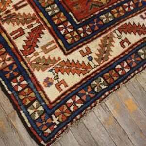 Close-up of a richly patterned area rug border featuring geometric motifs in red, blue, and cream, by Rugs On Net