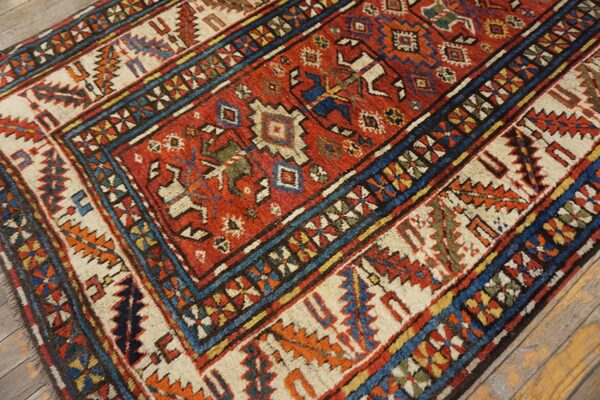 Close-up of a richly colored antique rug with geometric patterns and a dominant red field, by rugs on net