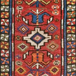 Close-up of a vibrant red tribal rug with geometric motifs in blue, white, and gold by Rugs On Net