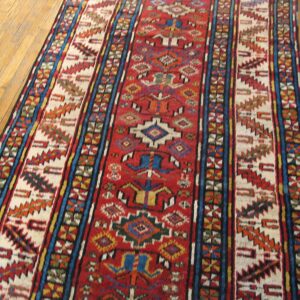 A vibrant, long runner rug with geometric patterns on a wooden floor by Rugs On Net. by Rugs On Net