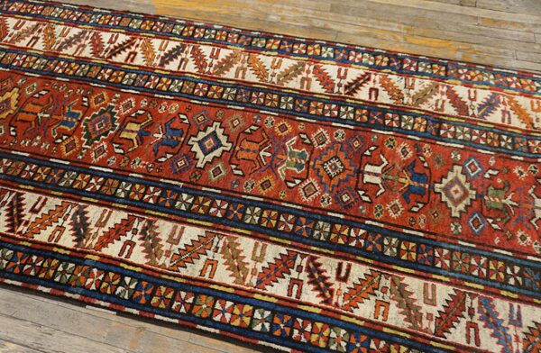 Close-up of a vibrant runner rug with geometric patterns in red, blue, and cream, by rugs on net. By rugs on net