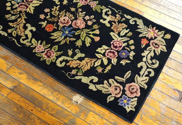 Close-up of a black rug with colorful floral embroidery, by rugs on net. By rugs on net