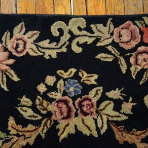 Close-up of a black rug with pink, red, blue, and gold floral embroidery, by Rugs On Net