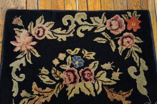 Close-up of a black rug with pink, red, blue, and gold floral embroidery, by rugs on net