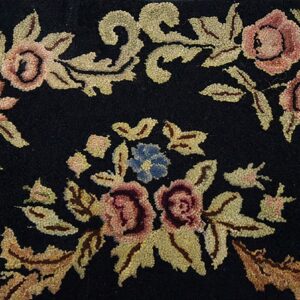 Close-up of a black rug featuring pink and orange floral motifs with green-gold leaves, by Rugs On Net