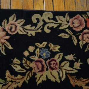 Close-up of a black rug featuring pink, red, and blue floral motifs with olive green leaves, by Rugs On Net. by Rugs On Net