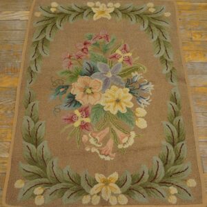 Hooked rug featuring a central floral bouquet framed by green leaves on a tan background, by Rugs On Net. by Rugs On Net