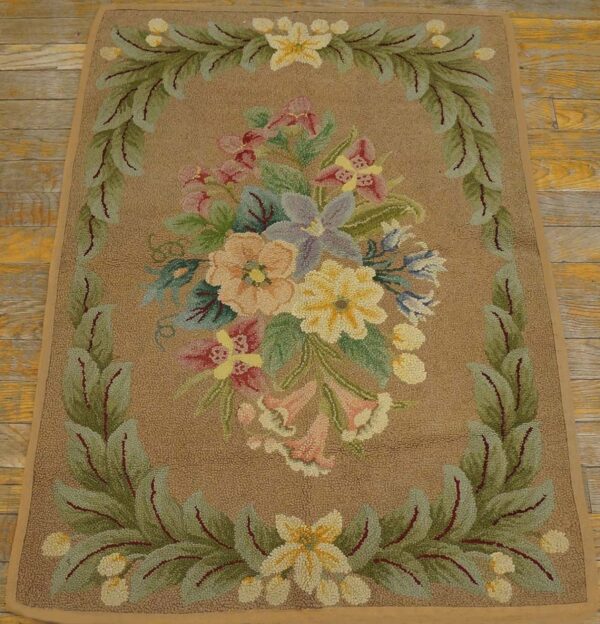 Hooked rug featuring a central floral bouquet framed by green leaves on a tan background, by rugs on net. By rugs on net