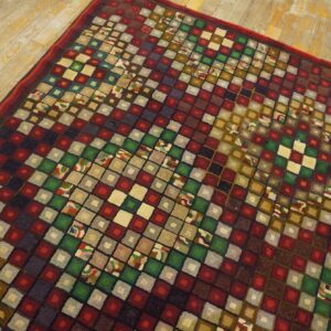 A vibrant, geometric rug with a checkerboard pattern of colorful squares on a wooden floor, by Rugs On Net