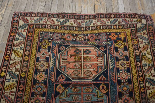 Close-up of a colorful antique rug with geometric patterns on a wooden floor by rugs on net