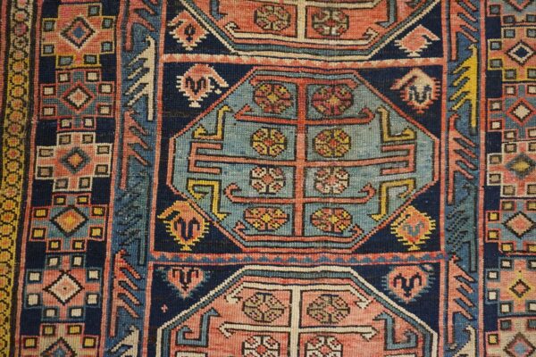 Close-up of geometric patterns and floral motifs in a vintage rug by rugs on net