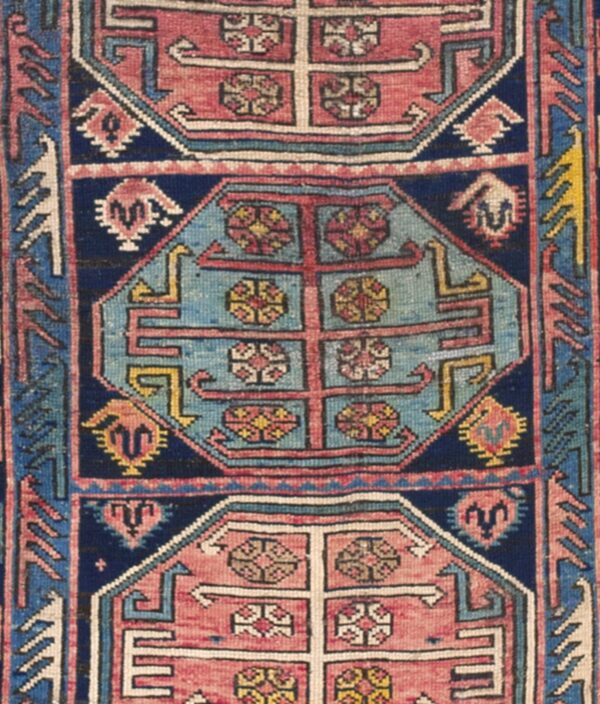 Detail of a geometric caucasian rug with blue and pink medallions by rugs on net