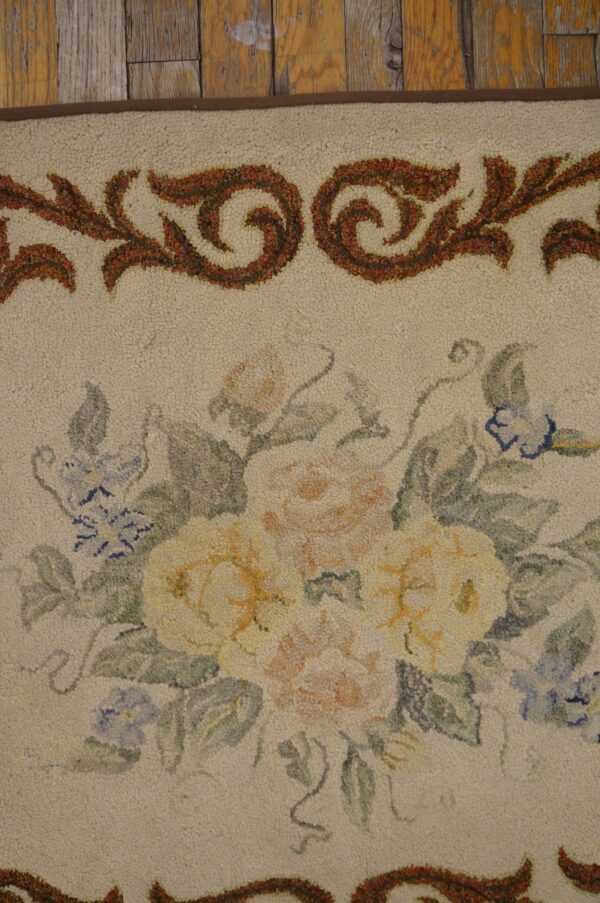 Close-up of a floral rug design featuring soft yellow and pink roses with blue accents on a cream background, framed by an ornate brown border, by rugs on net