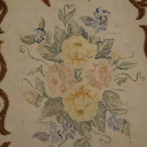 Close-up of a floral hooked rug with yellow and pink roses and blue accents, framed by brown scrollwork, by Rugs On Net