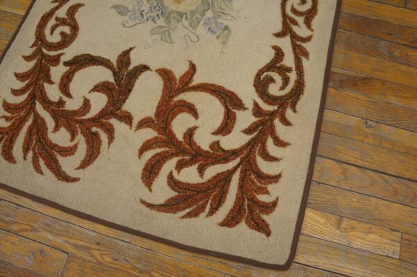 Close-up of a beige rug with burnt orange scrollwork border design on a wooden floor by rugs on net
