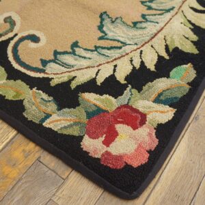 Close-up of a floral rug corner featuring red flowers and green leaves on a black border, by Rugs On Net