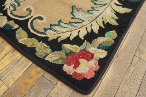 Close-up of a floral rug corner featuring red flowers and green leaves on a black border, by rugs on net